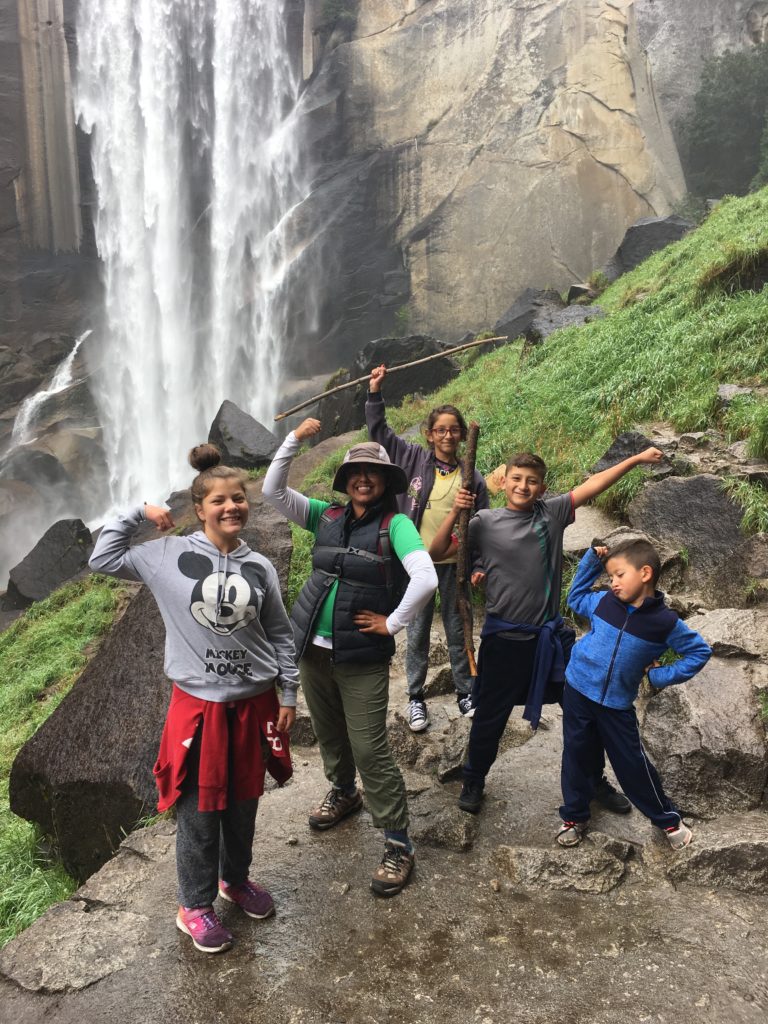 Vamos Afuera group posing in front of a waterfall at Yosemite