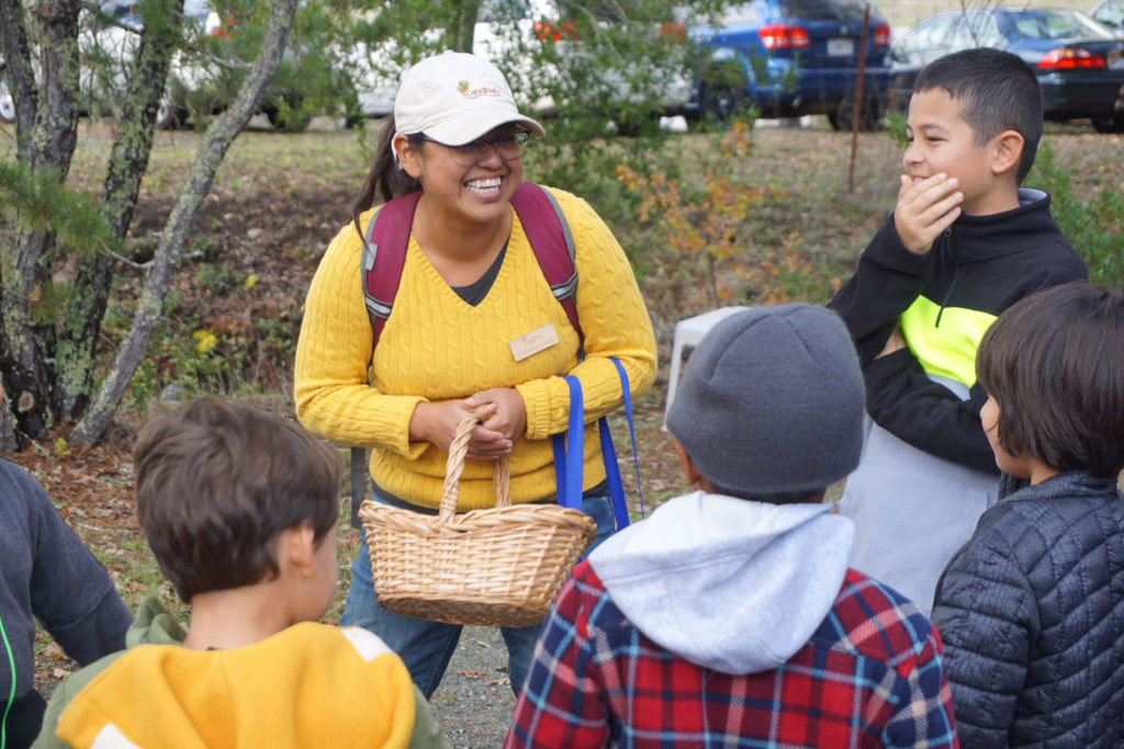 Guadalupe Casco, a LandPaths' staff member laughing with a group of kids