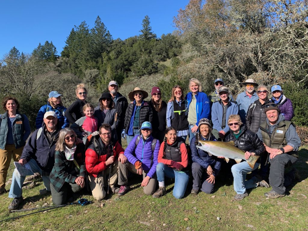 20 people smile in a group at Saddle Mountain.